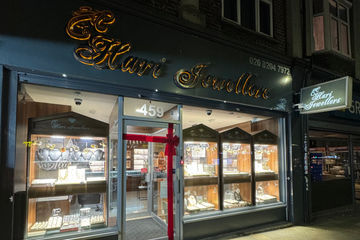 Storefront of a jewelry store with illuminated sign at night
